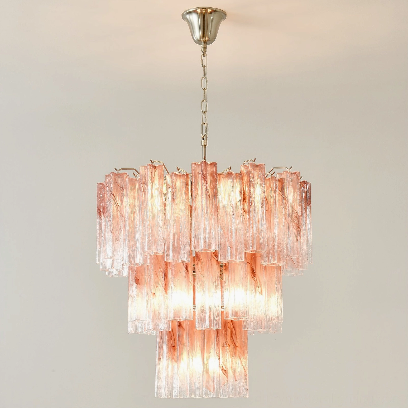 Pink Murano tube chandelier with Edison bulb showing warm vintage filament light through pink glass