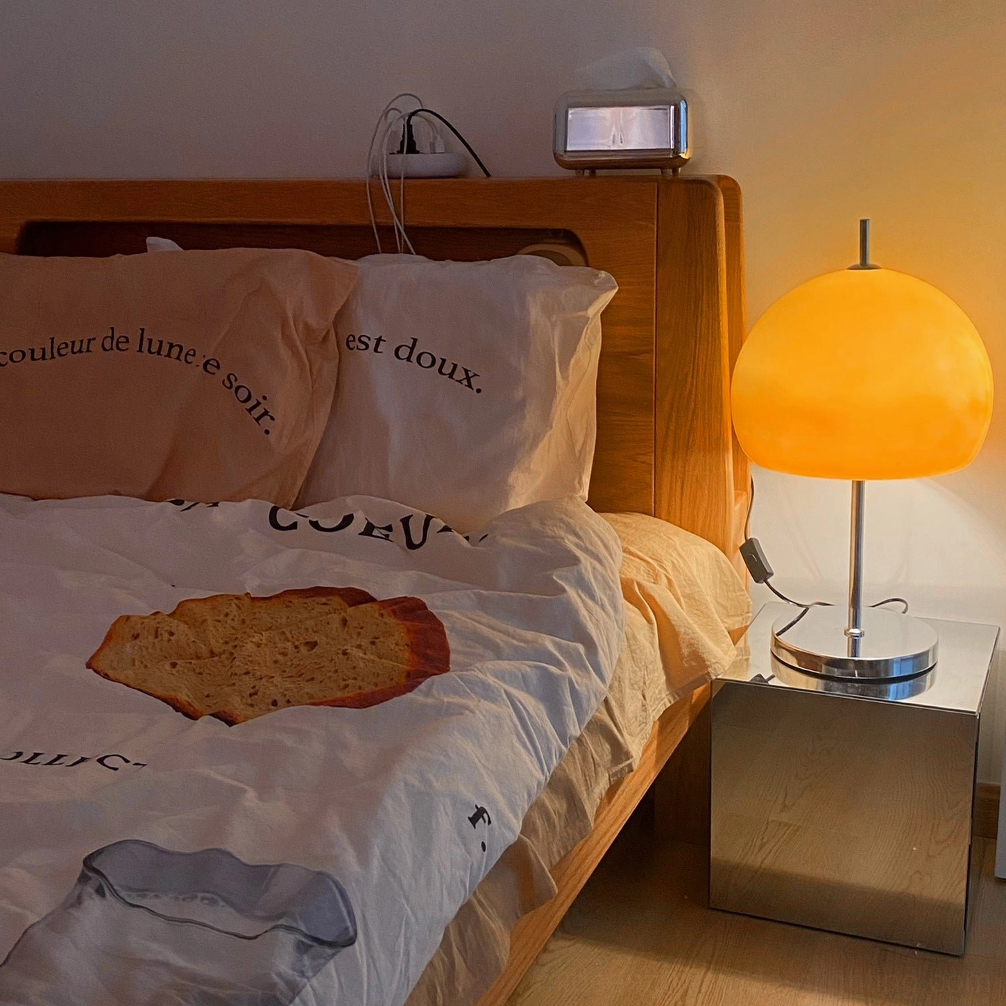 Retro mushroom table lamp providing soft bedside illumination with wooden bed frame in master bedroom