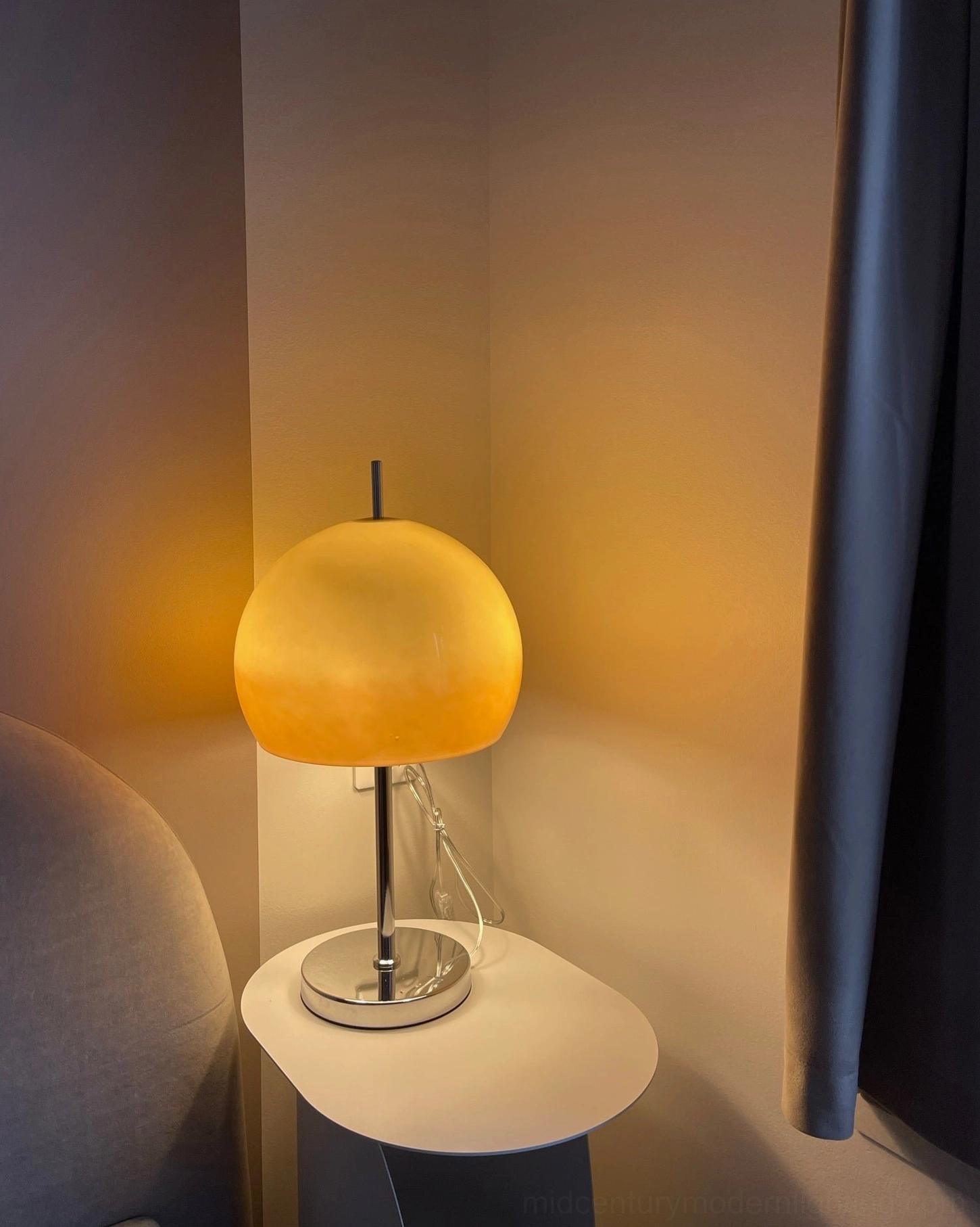 Mid-century modern mushroom table lamp with glowing warm shade in industrial loft apartment setting