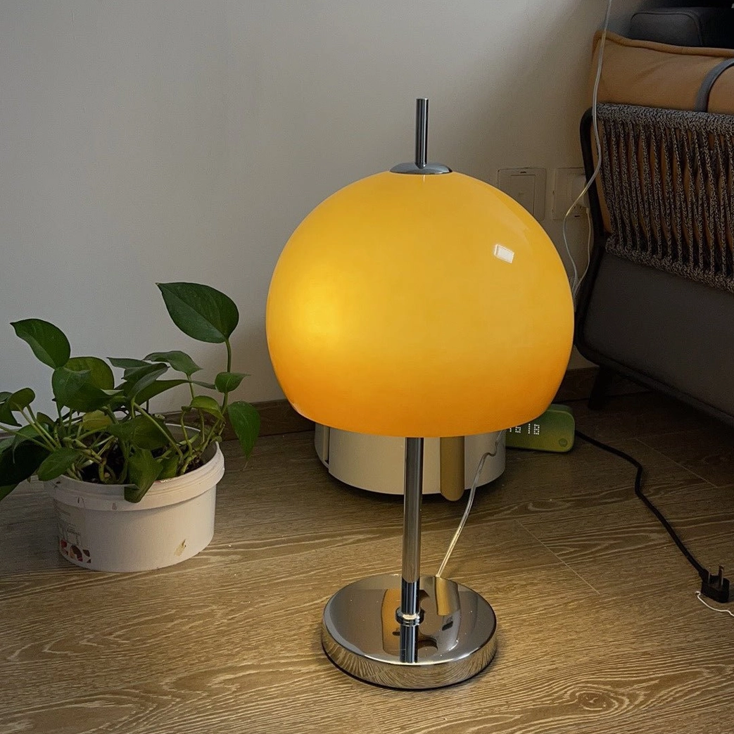 Mushroom lamp with warm glowing amber shade in bedroom nightstand styling arrangement