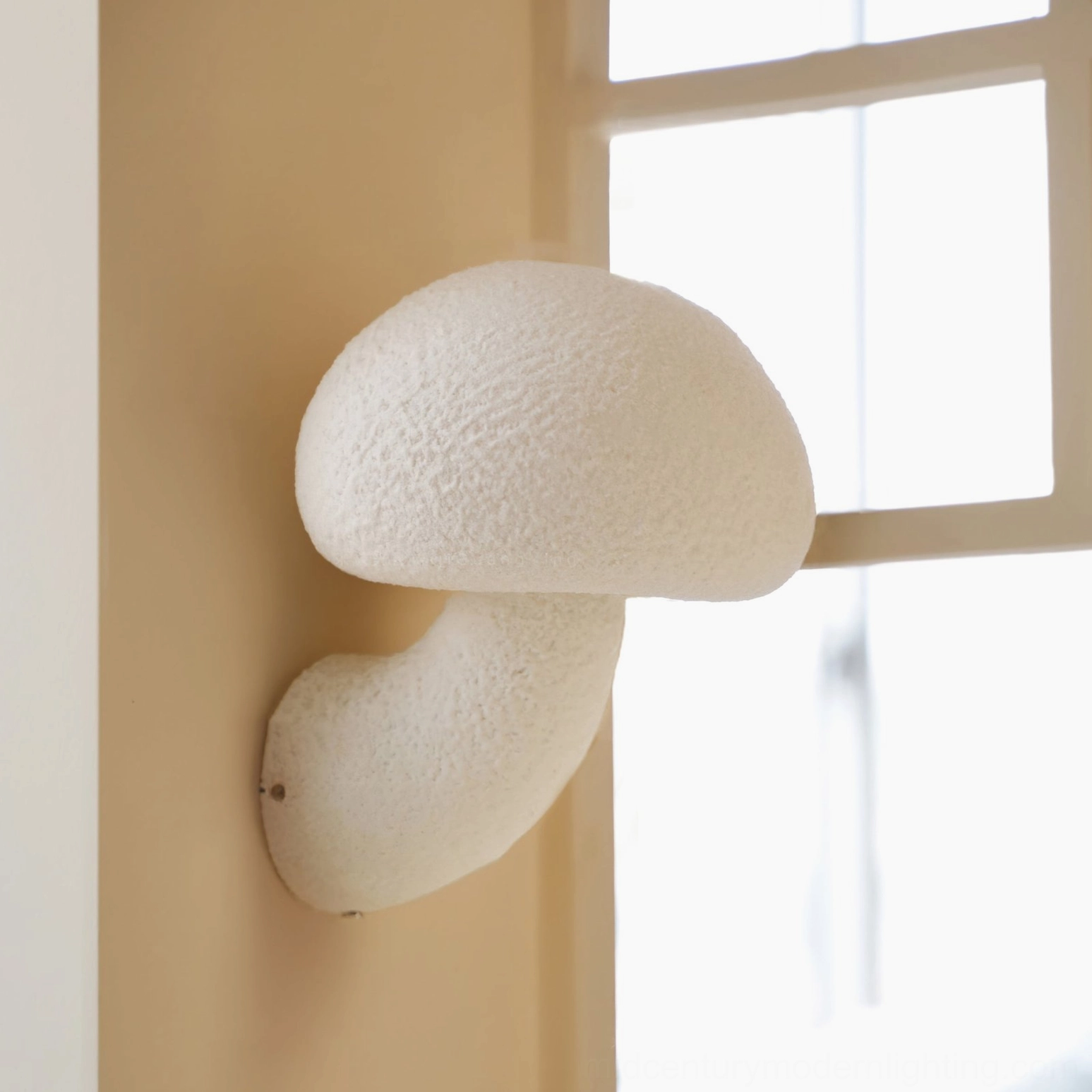 Mushroom resin wall lamp mounted near window - natural light home interior setting modern design