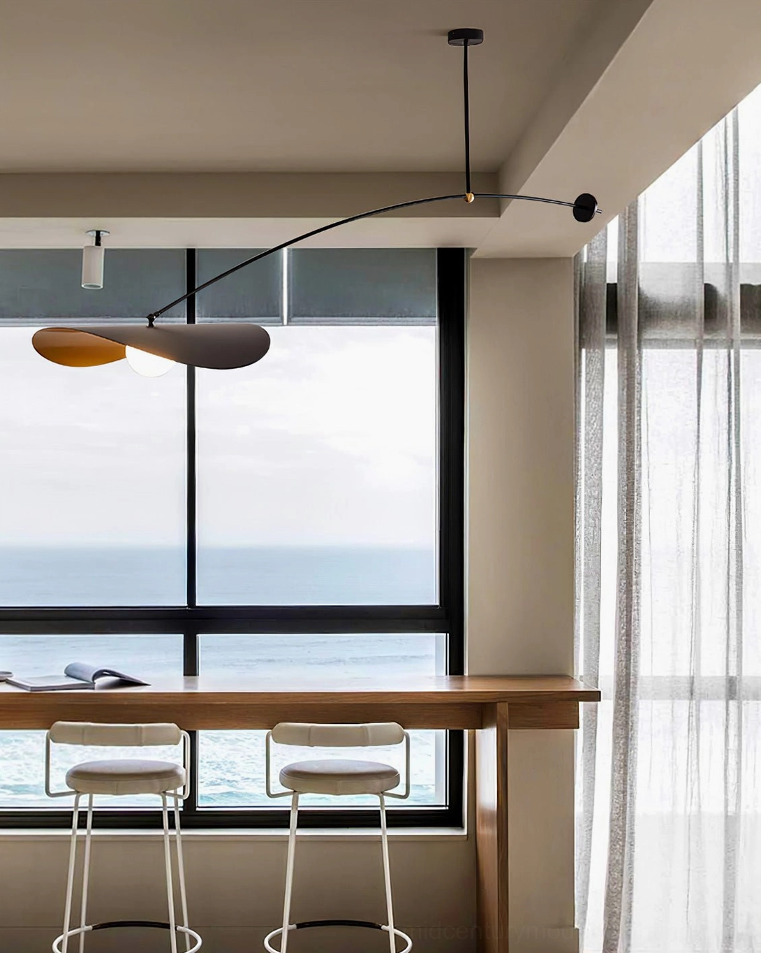 Myrna counterweight chandelier in bright airy coastal dining area with sea view windows, contemporary home styling