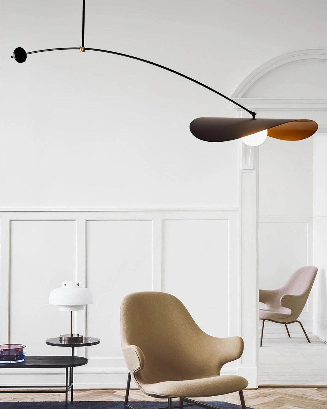 Myrna arc pendant light installed in modern minimalist living room with accent chair, mid-century modern home interior