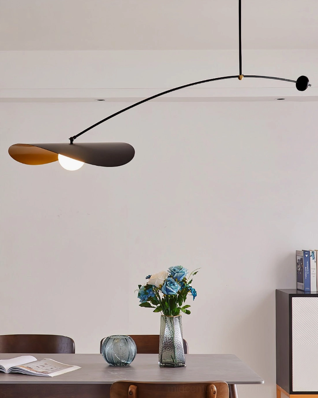 Myrna arc ceiling pendant above dining table with floral centerpiece, warm neutral minimalist home decor