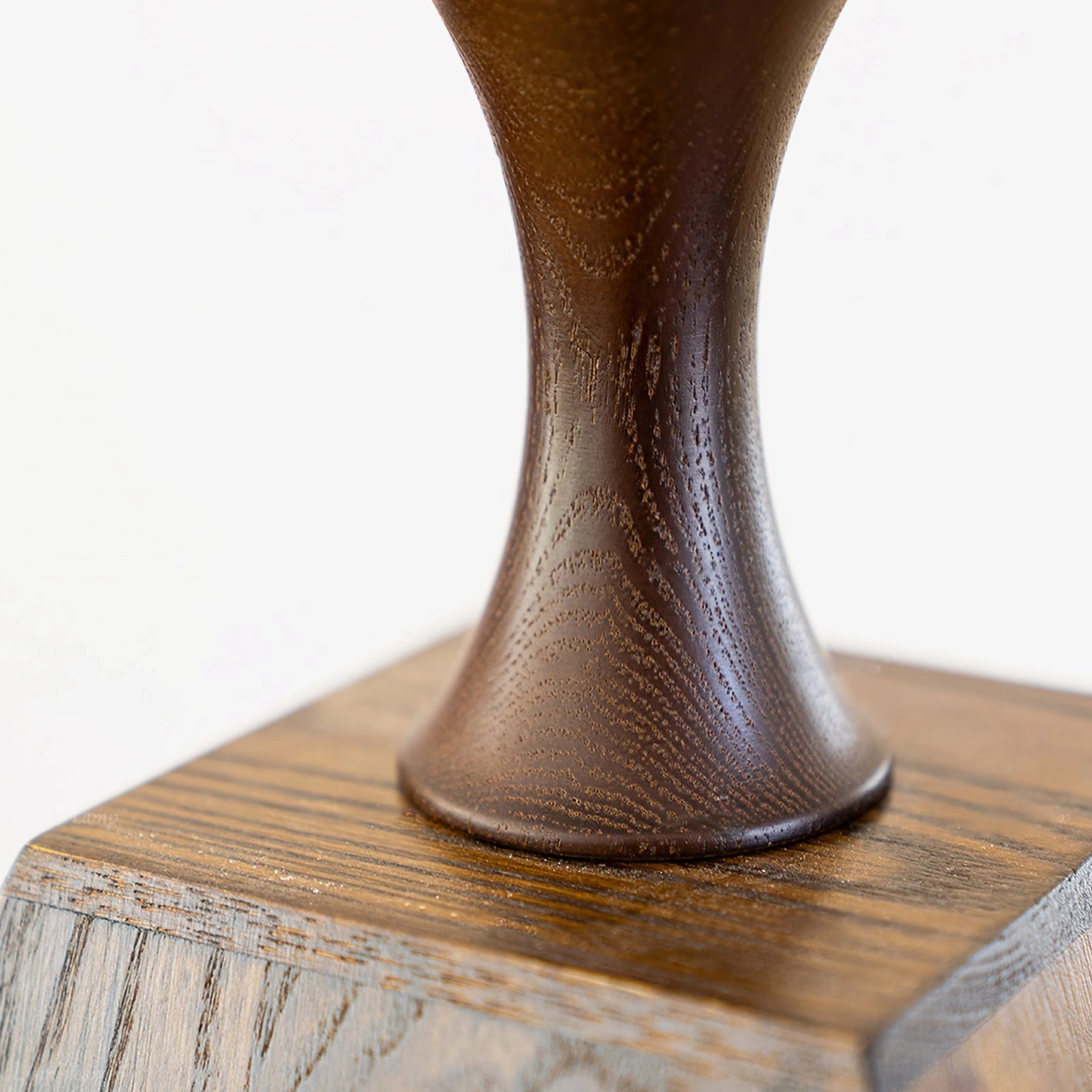 Close-up macro photograph of Mysore lamp's turned walnut wood base, showing authentic wood grain and artisanal craftsmanship details