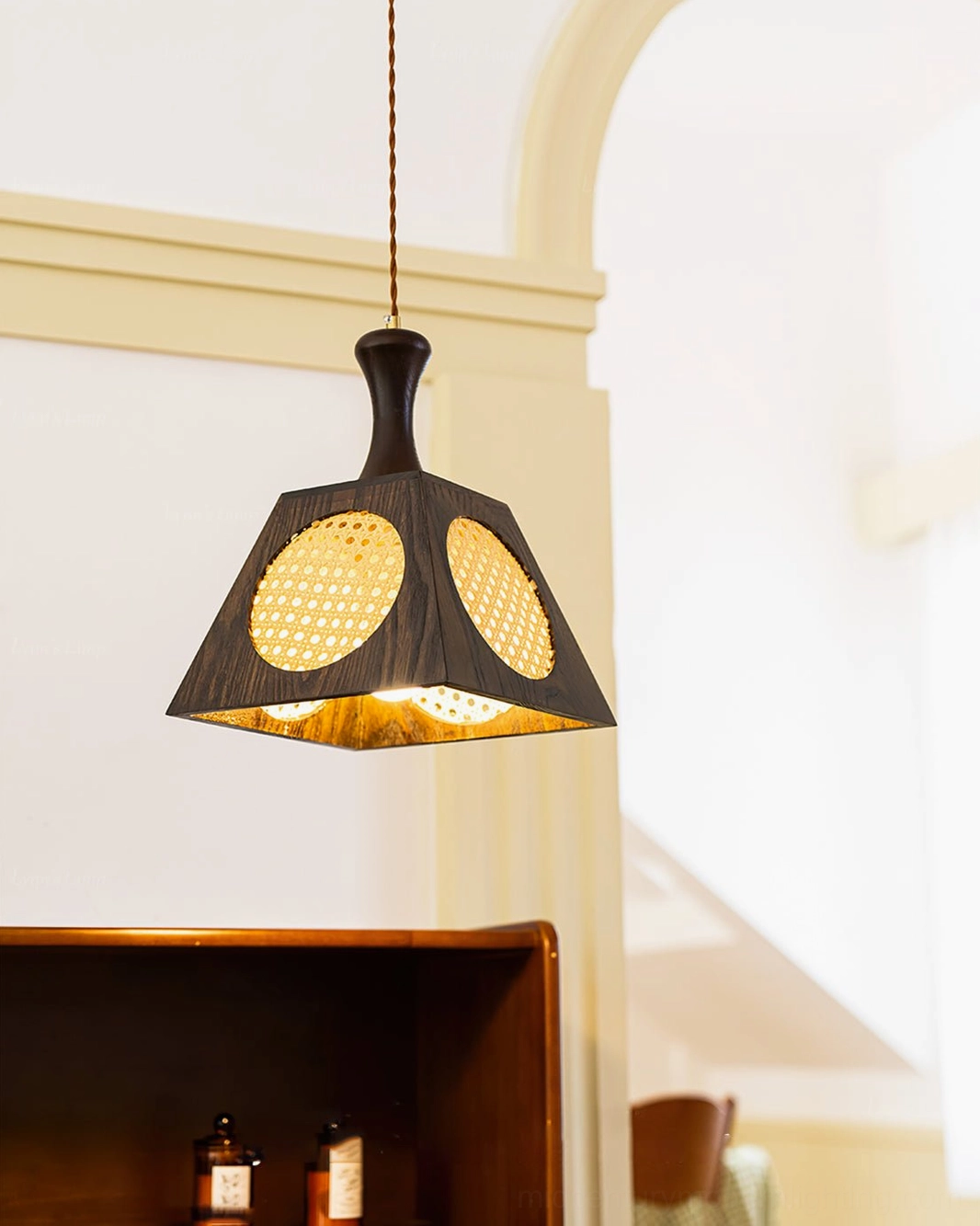 Mid-century pendant lamp with dual rattan panels displayed in vintage archway study area, side hanging view with natural lighting