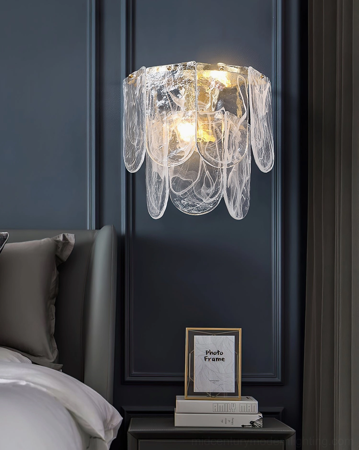 Nason brass wall sconce close-up in modern bedroom with dark blue accent wall, warm ambient glow illumination