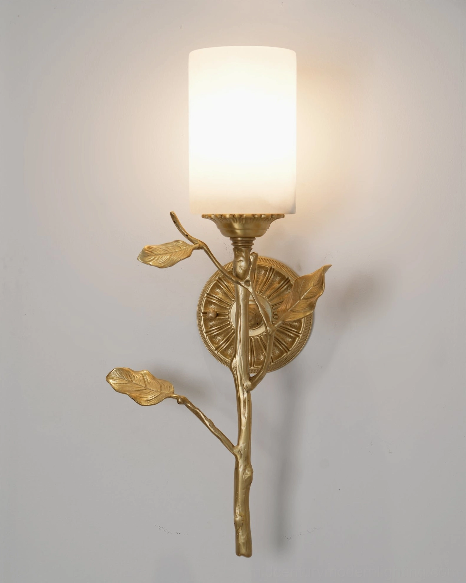 Close-up detail of illuminated Natalia cylindrical frosted alabaster shade with brass leaf branch accent