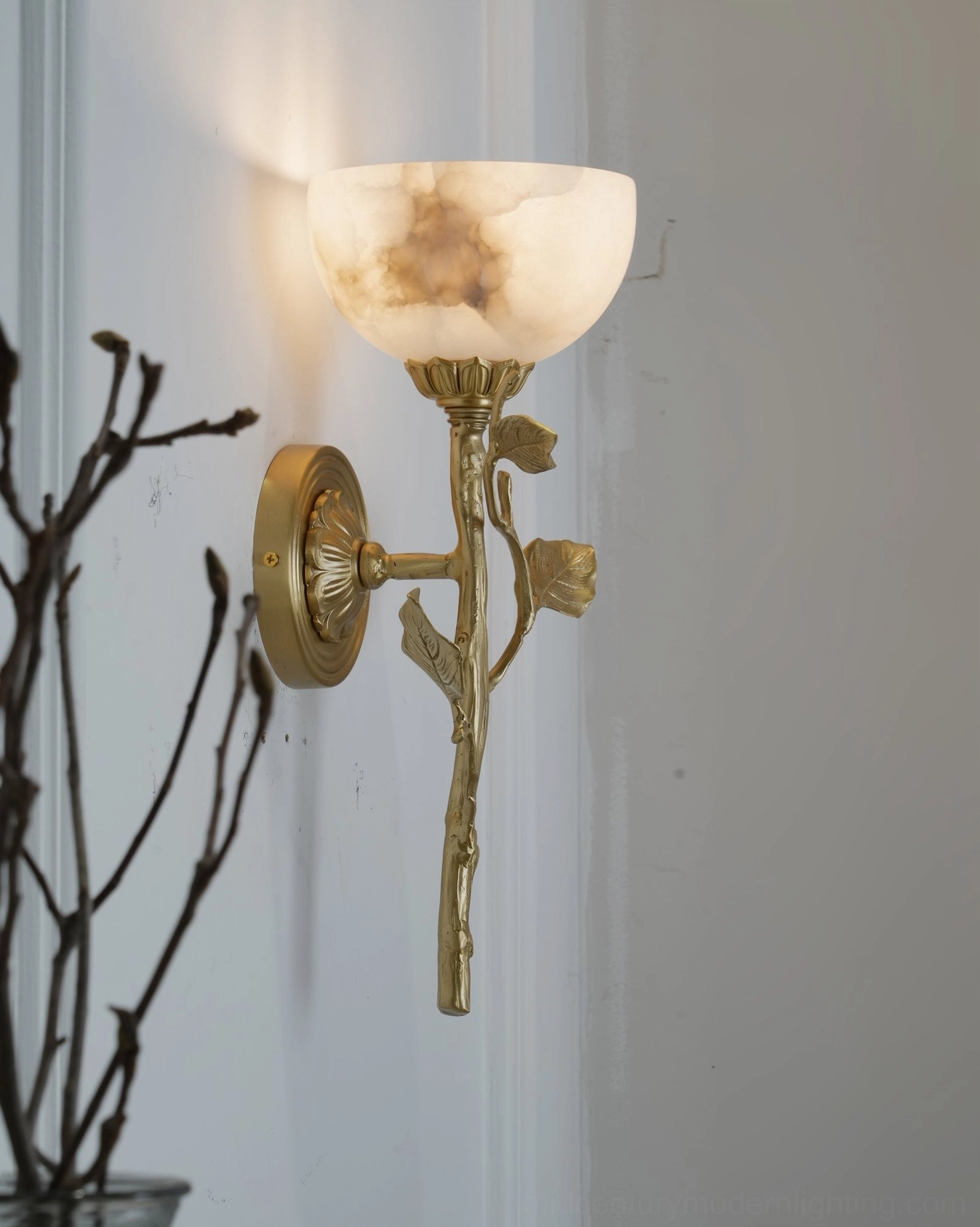 Natalia brass bowl-shaped alabaster sconce with veined stone detail and branch-style brass arm from side angle