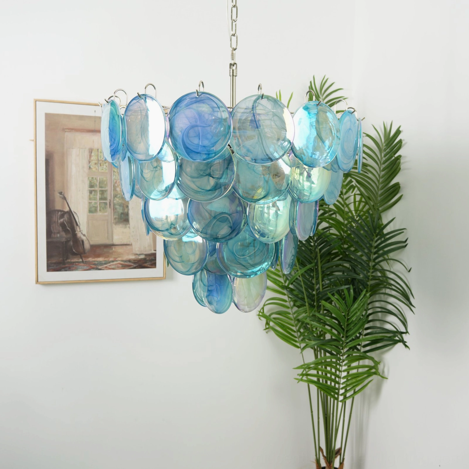 Navy blue glass disc chandelier with deep watercolor tint and tiered cluster design, three-quarter front view in home interior