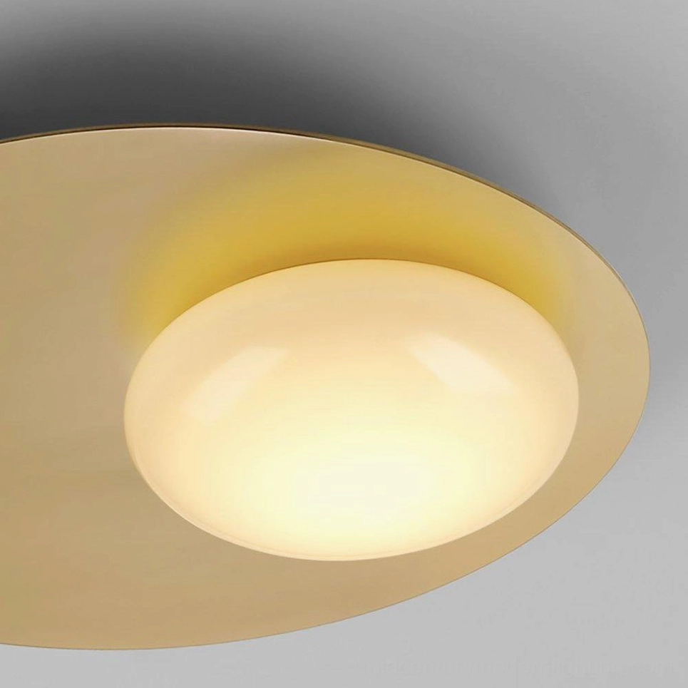 Close-up detail of Nodes wall sconce showing illuminated frosted glass and warm brushed brass metalwork