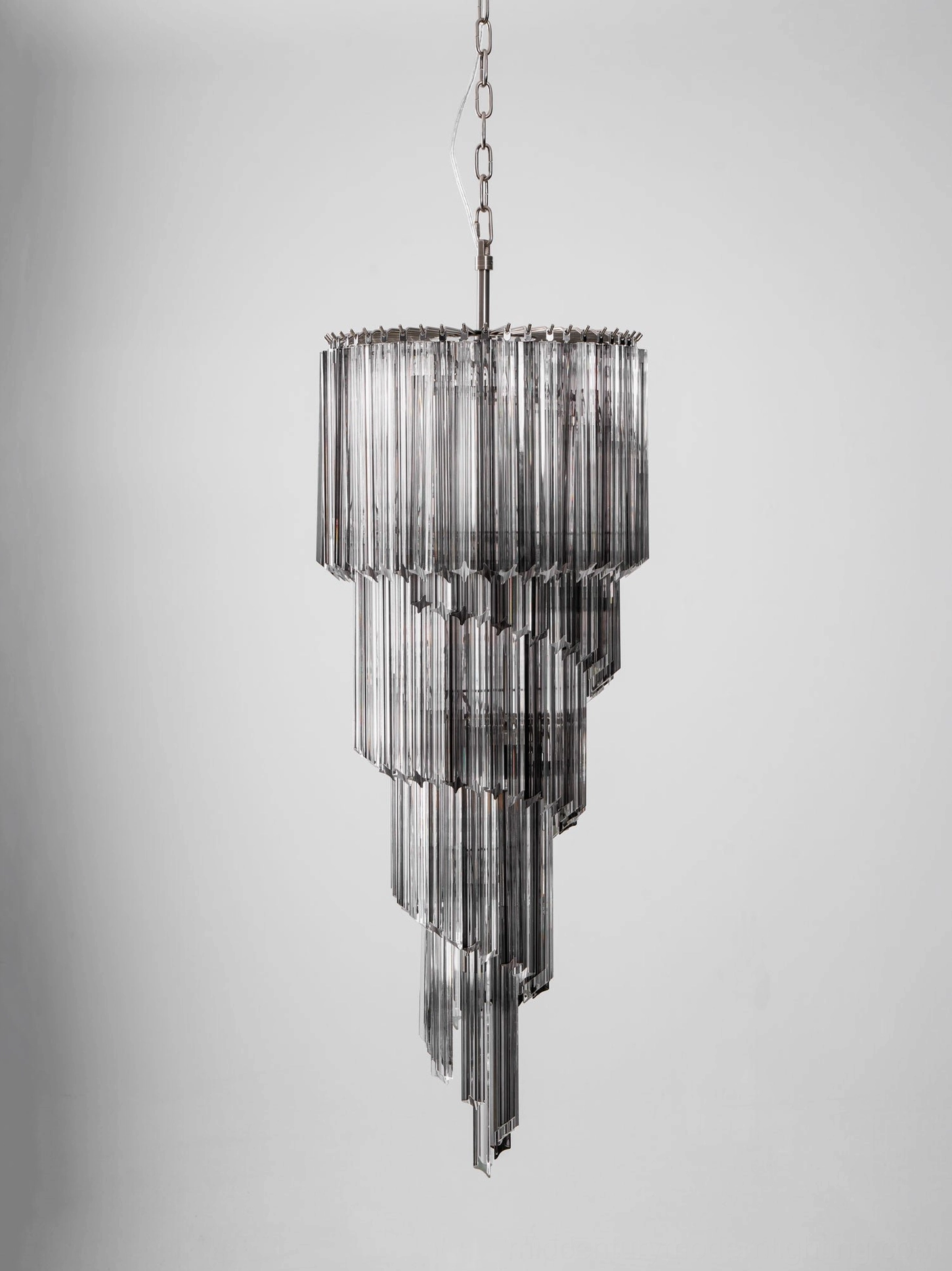 Contemporary spiral glass chandelier lighting effect in evening ambiance, warm glow through layers