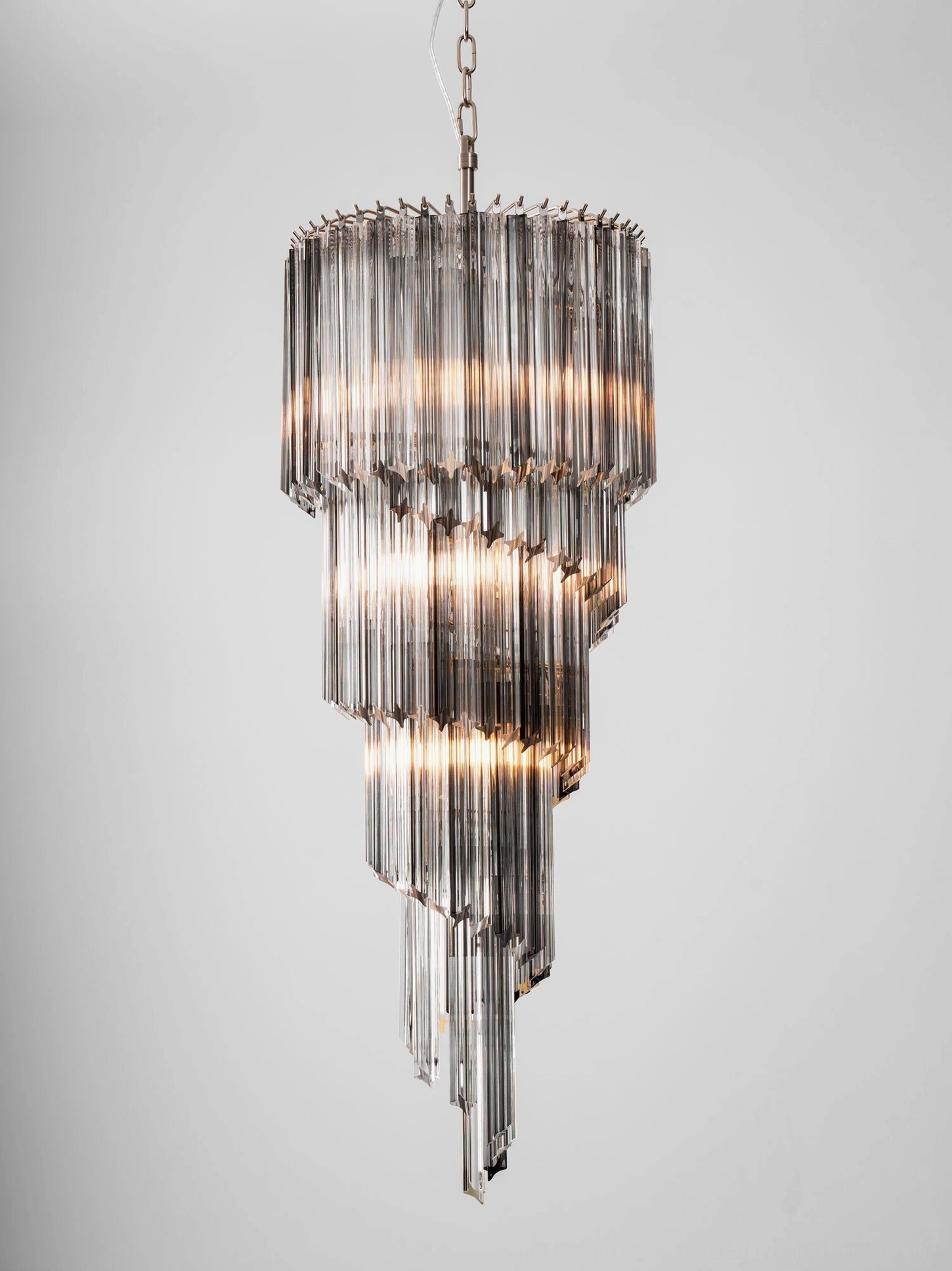 Close-up frontal view of illuminated Noir spiral chandelier showing glass tiers and metal framework detail