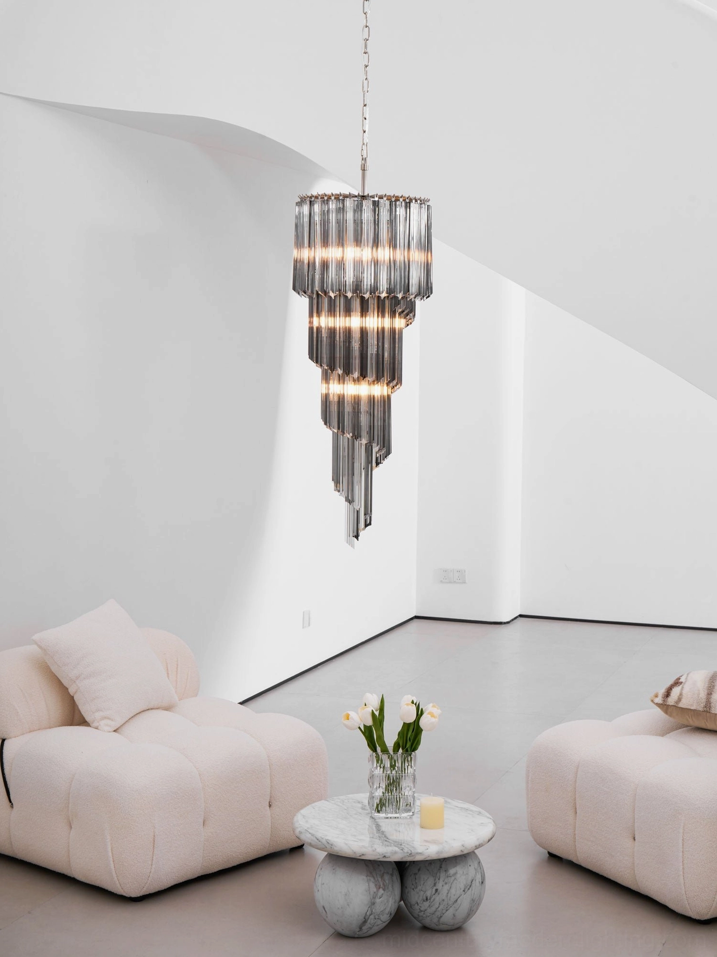 Contemporary spiral glass chandelier showing geometric cascade and light diffusion through smoked tiers