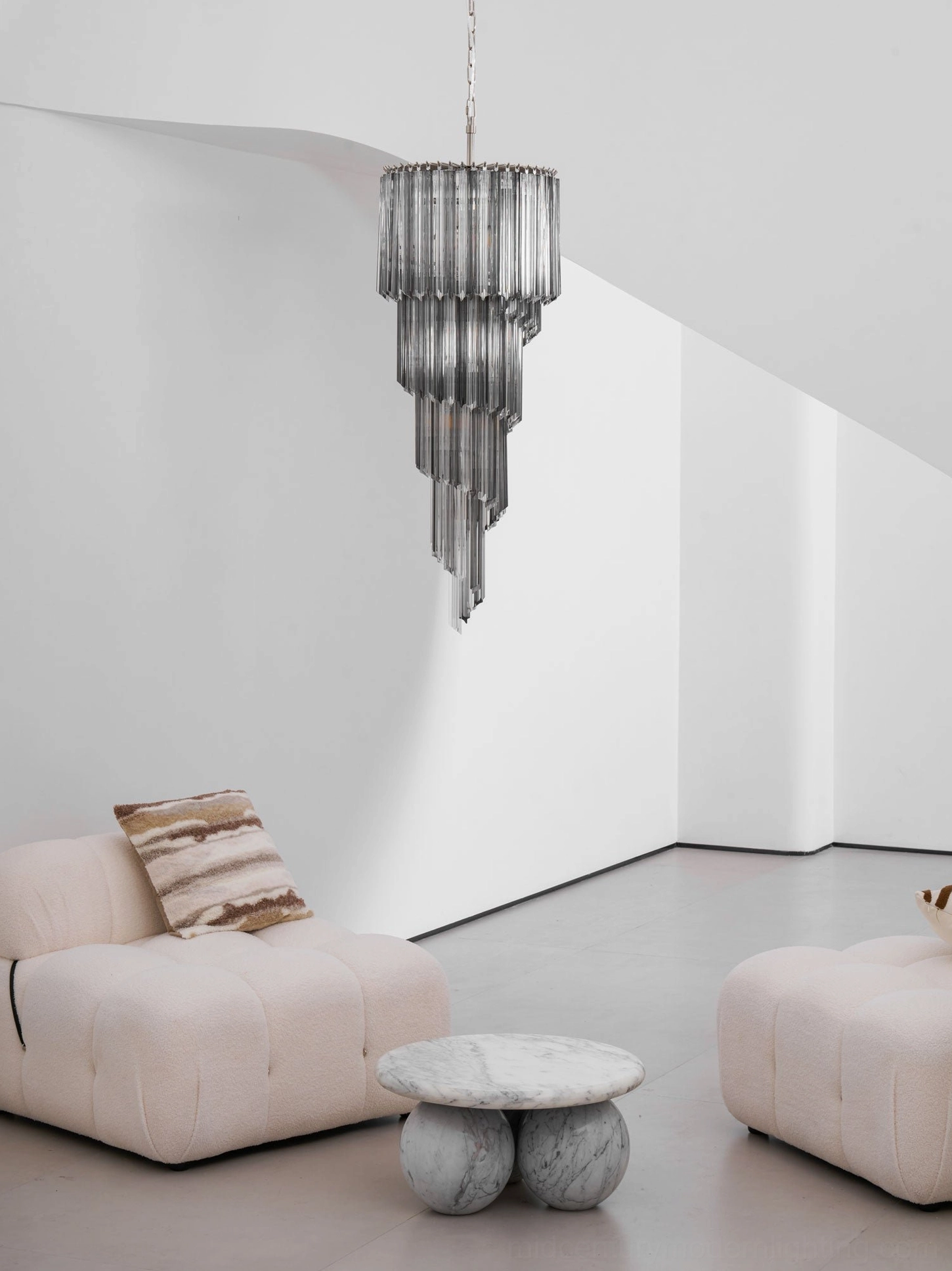Smoked gradient glass spiral chandelier above marble side table, mid-century modern interior styling