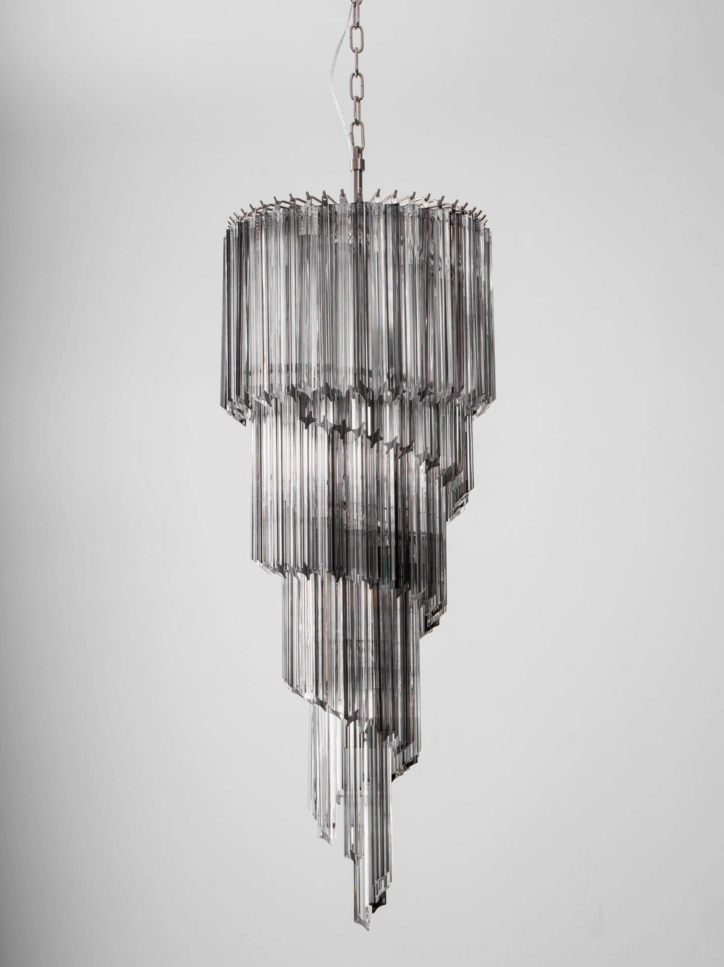 Dark smoked glass spiral silhouette of Noir chandelier, frontal hanging view studio background