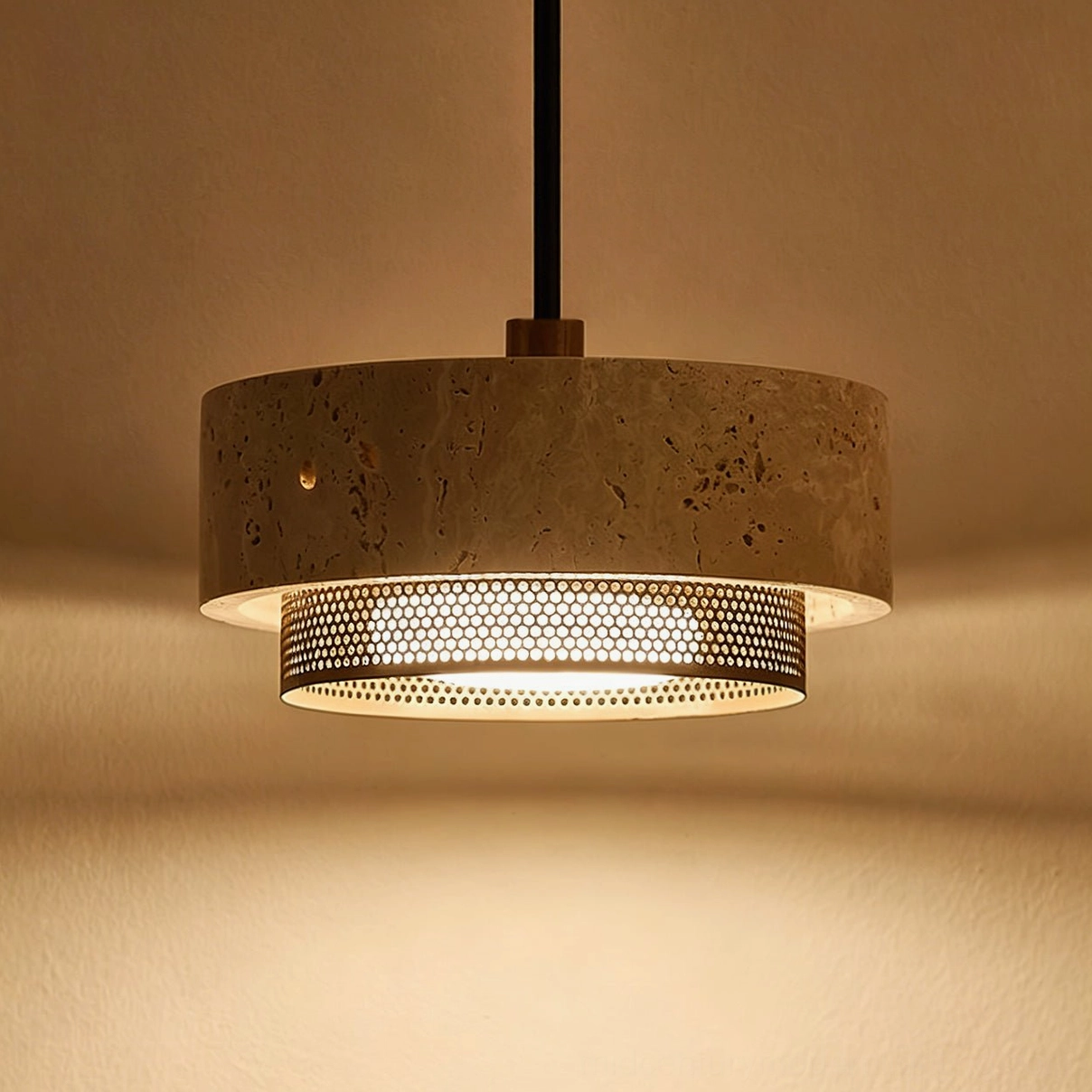 Illuminated Nolan travertine pendant light emitting warm ambient glow, highlighting natural stone texture and mineral veining when lit