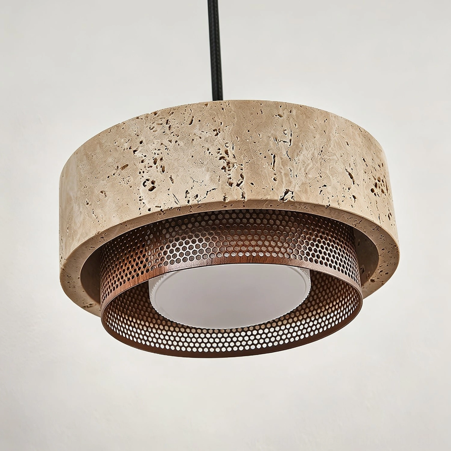 Close-up front view of Nolan pendant showing travertine stone detail, fissures, pits, and bronze-finish metal trim architectural frame