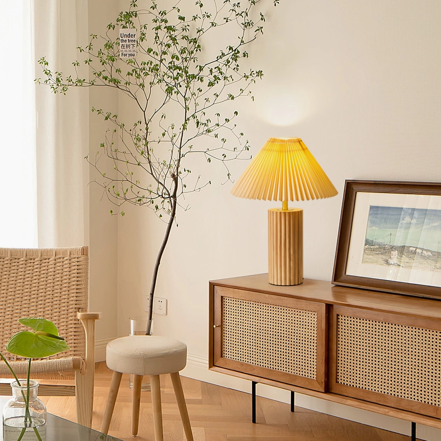 Nora table lamp positioned on living room sideboard with houseplants and framed artwork