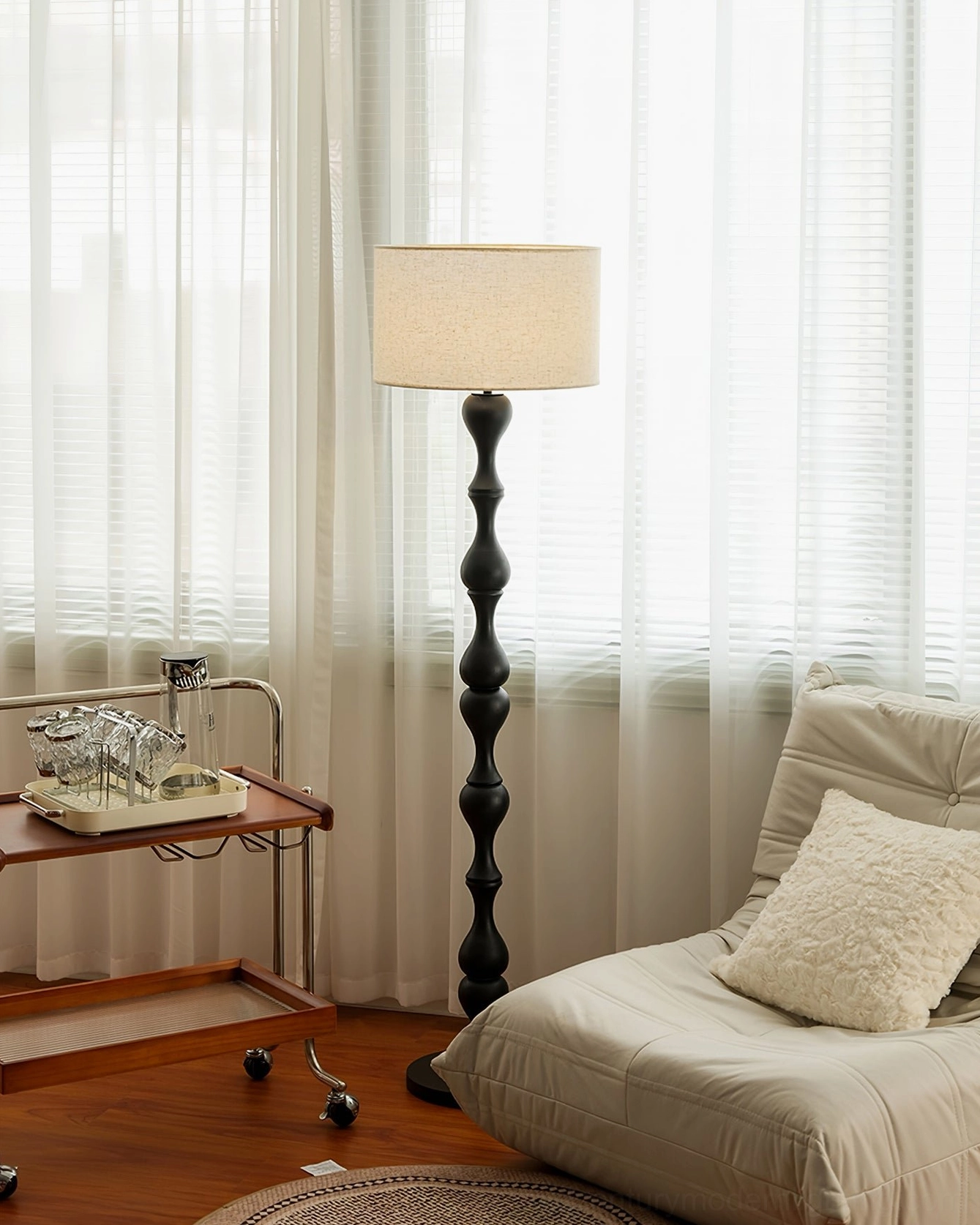 Modern rustic living room featuring black Norden carved floor lamp beside rolling trolley and lounge sofa