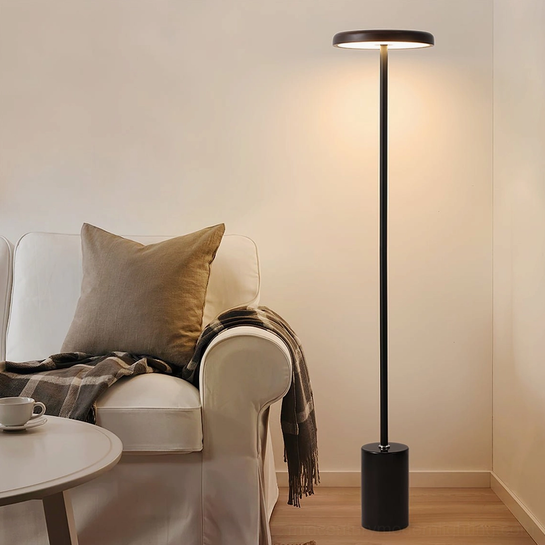 Contemporary floor lamp next to upholstered armchair in living room, modern reading light with warm neutral tones