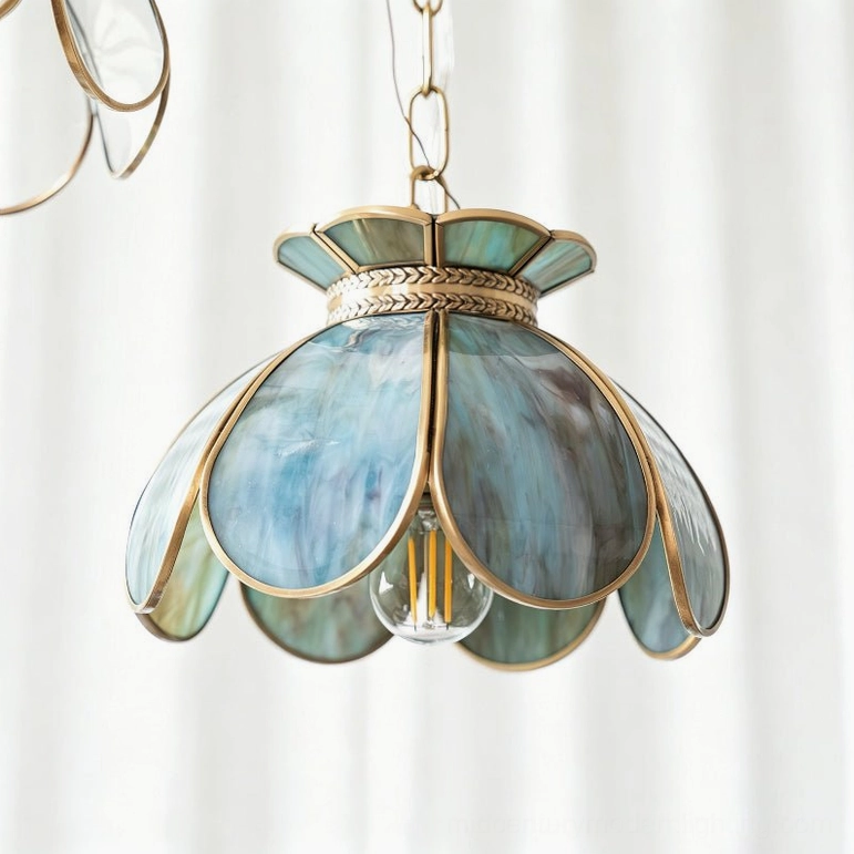 Close-up detail of Odette blue-teal stained glass pendant with scalloped petals and brass wheat-ear filigree collar