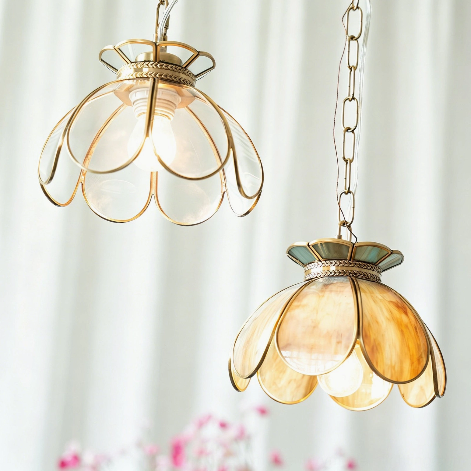 Overhead view of two Odette pendant lights in gold-amber and clear glass with wheat-ear filigree brass trim