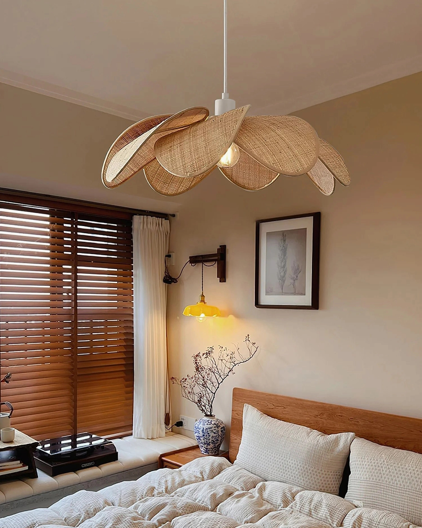 Odilia handwoven rattan pendant light in warm rustic bedroom setting, side front view demonstrating natural golden tones and light diffusion