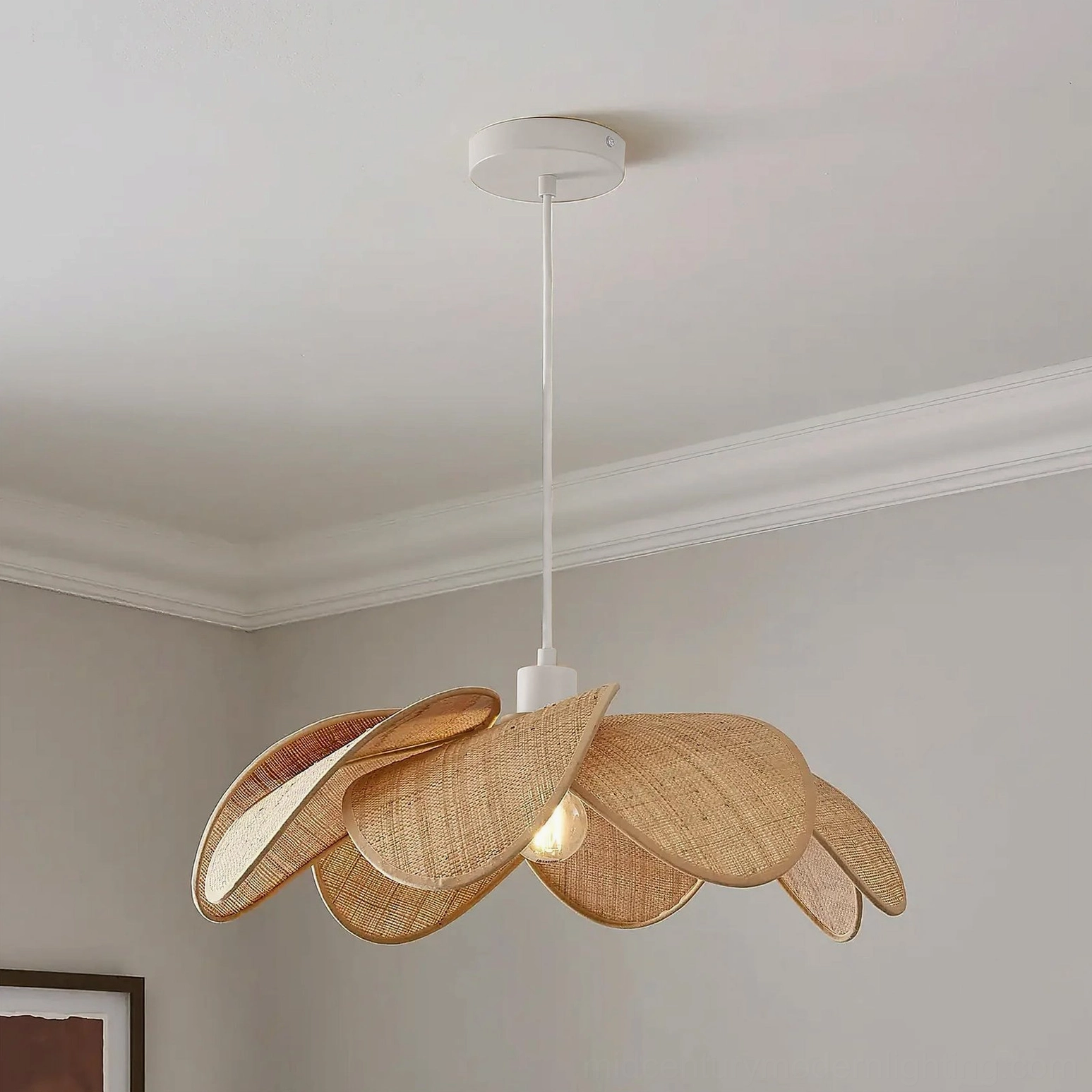 Odilia rattan pendant light installed in minimalist residential ceiling corner, three-quarter side angle showing organic petal layers and warm ambient glow