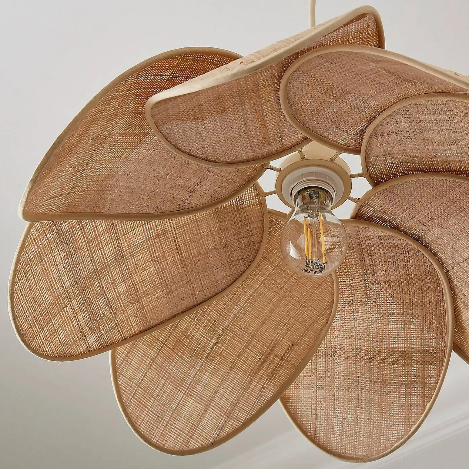 Odilia rattan pendant light bottom close-up detail, showing woven rattan structure, E26 E27 bulb socket, and layered petal construction