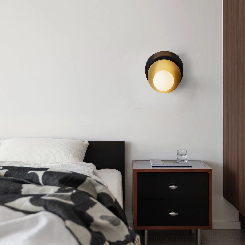 Olivia black and brass wall sconce installed in modern minimalist bedroom above nightstand