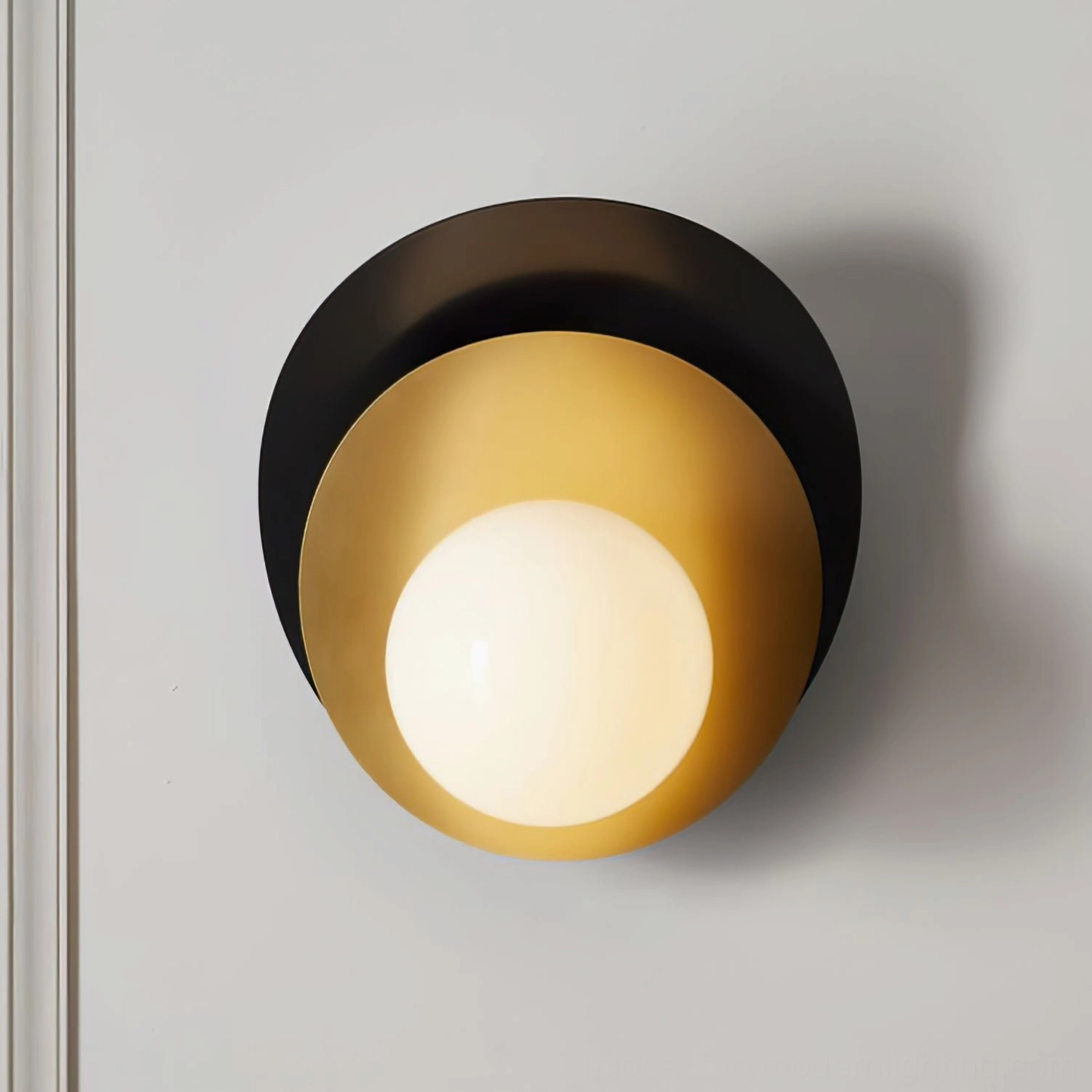Fully illuminated Olivia wall lamp with frosted white glass and black brass framework casting warm ambient light