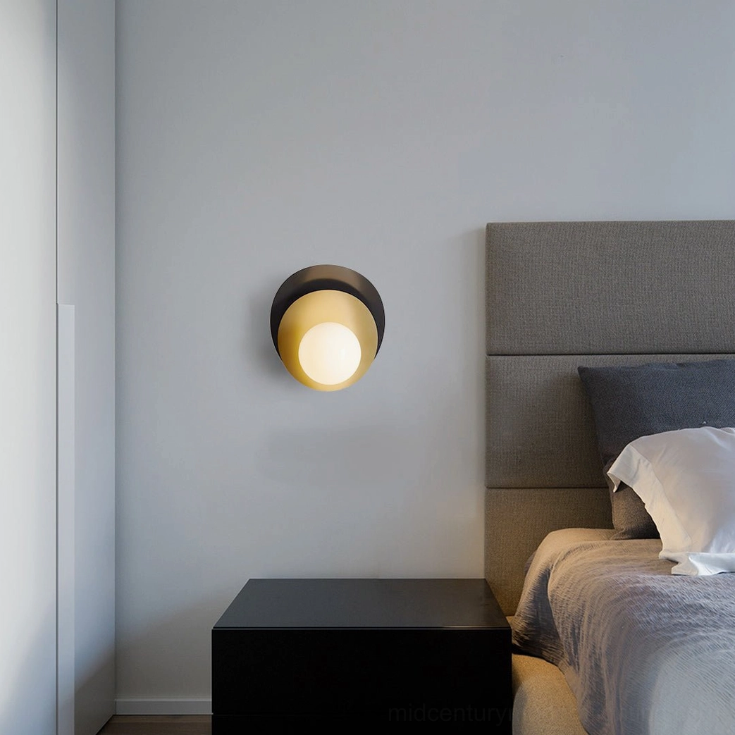 Olivia compact wall lamp mounted in minimalist bedroom with fabric headboard and unobtrusive modern design