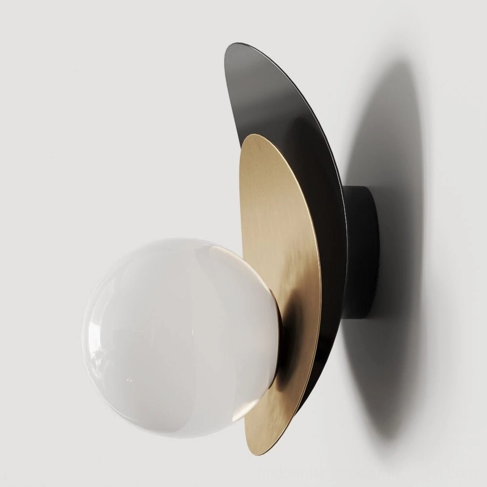 Side close-up of Olivia wall sconce showing asymmetrical layered disc construction in brass and black with oversized glass globe