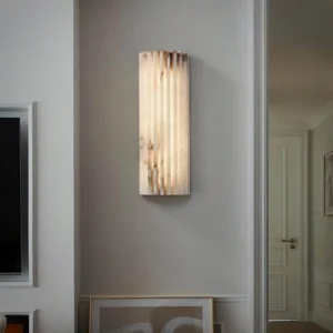 Ondas alabaster wall lamp installed in modern living room entryway, creating warm ambient light through translucent stone
