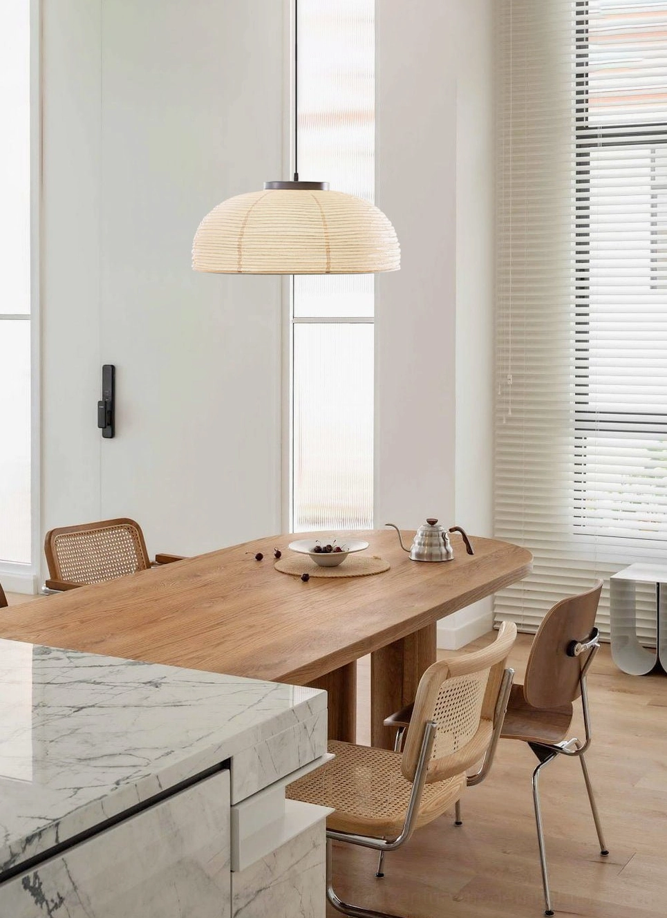 Open kitchen-dining space with modern paper pendant lamp – bright minimalist home interior
