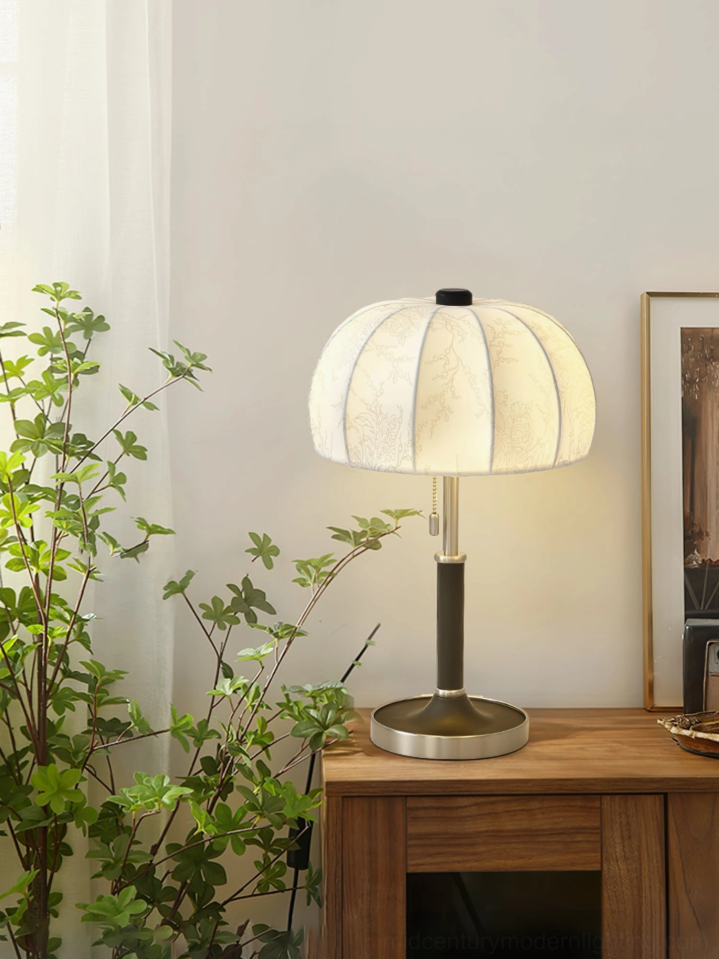 Mid-century modern table lamp with silver metal base on bedroom wooden side table with decor