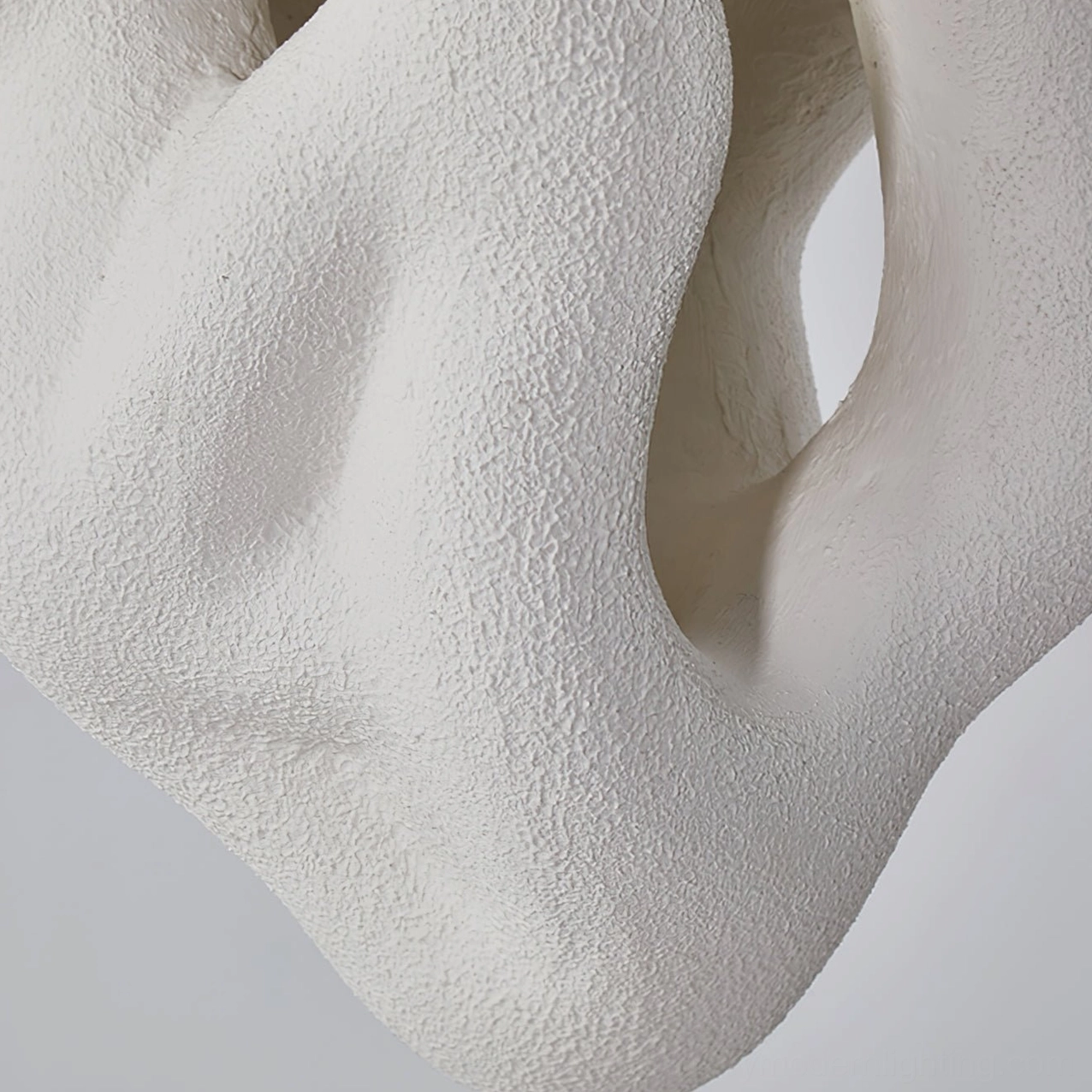 Partial view of organic nest pendant showing hollow cavity structure, porous biomimetic design element