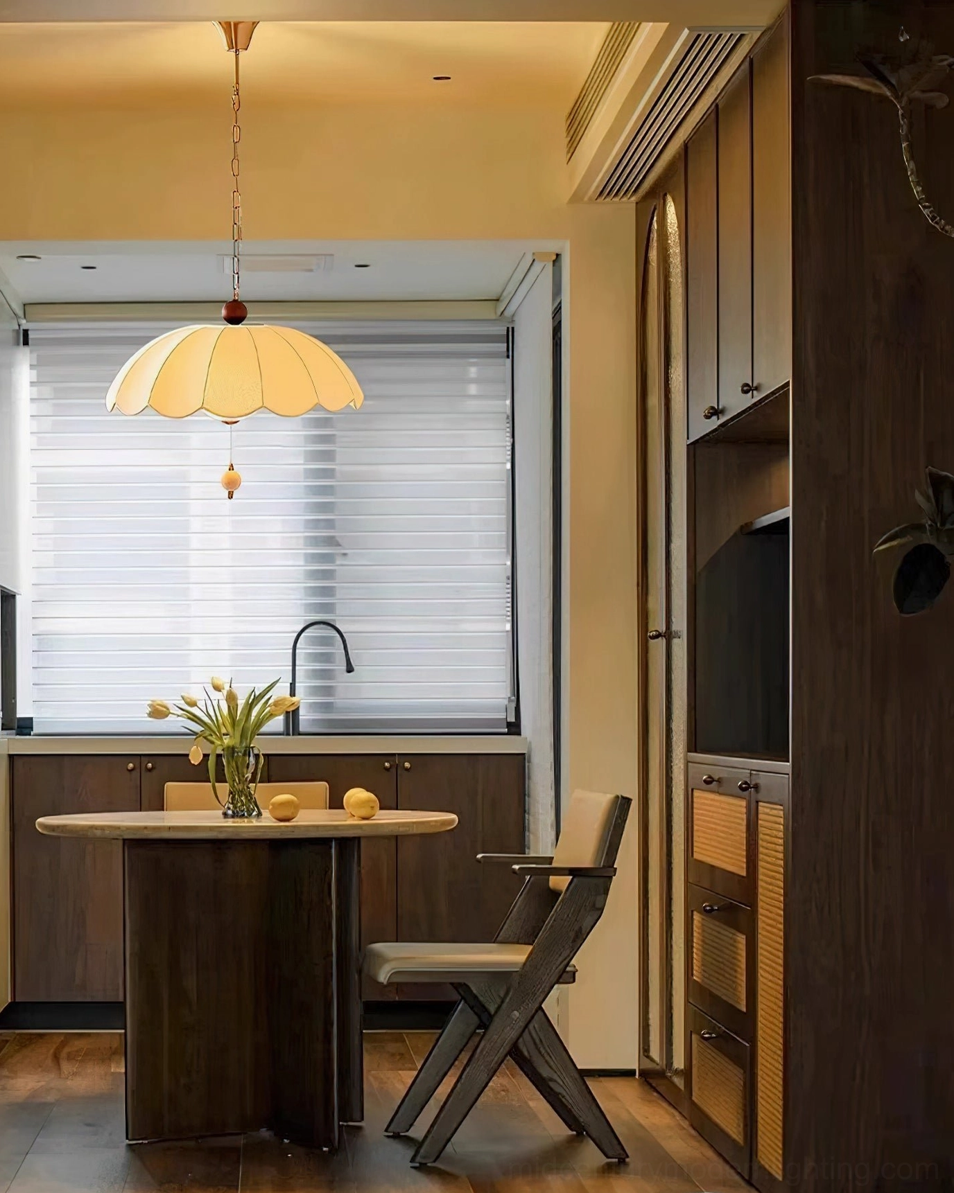 Oriente pendant light installed above dining table in residential kitchen interior, warm ambient lighting