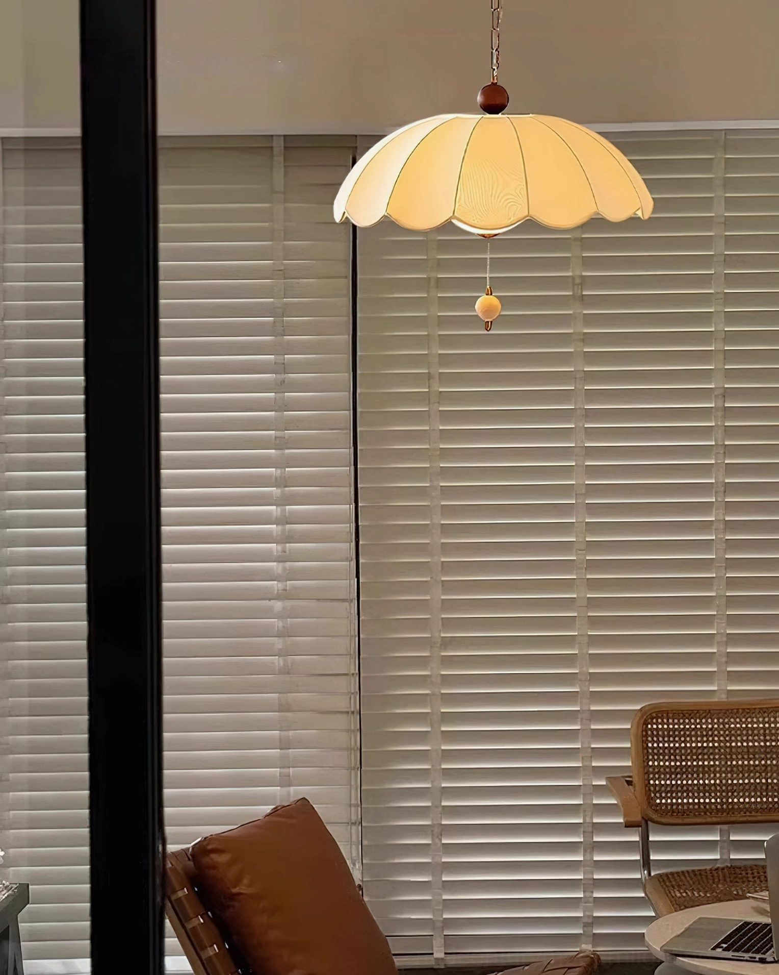 Oriente scalloped pendant light in lounge setting near rattan furniture and louvered windows