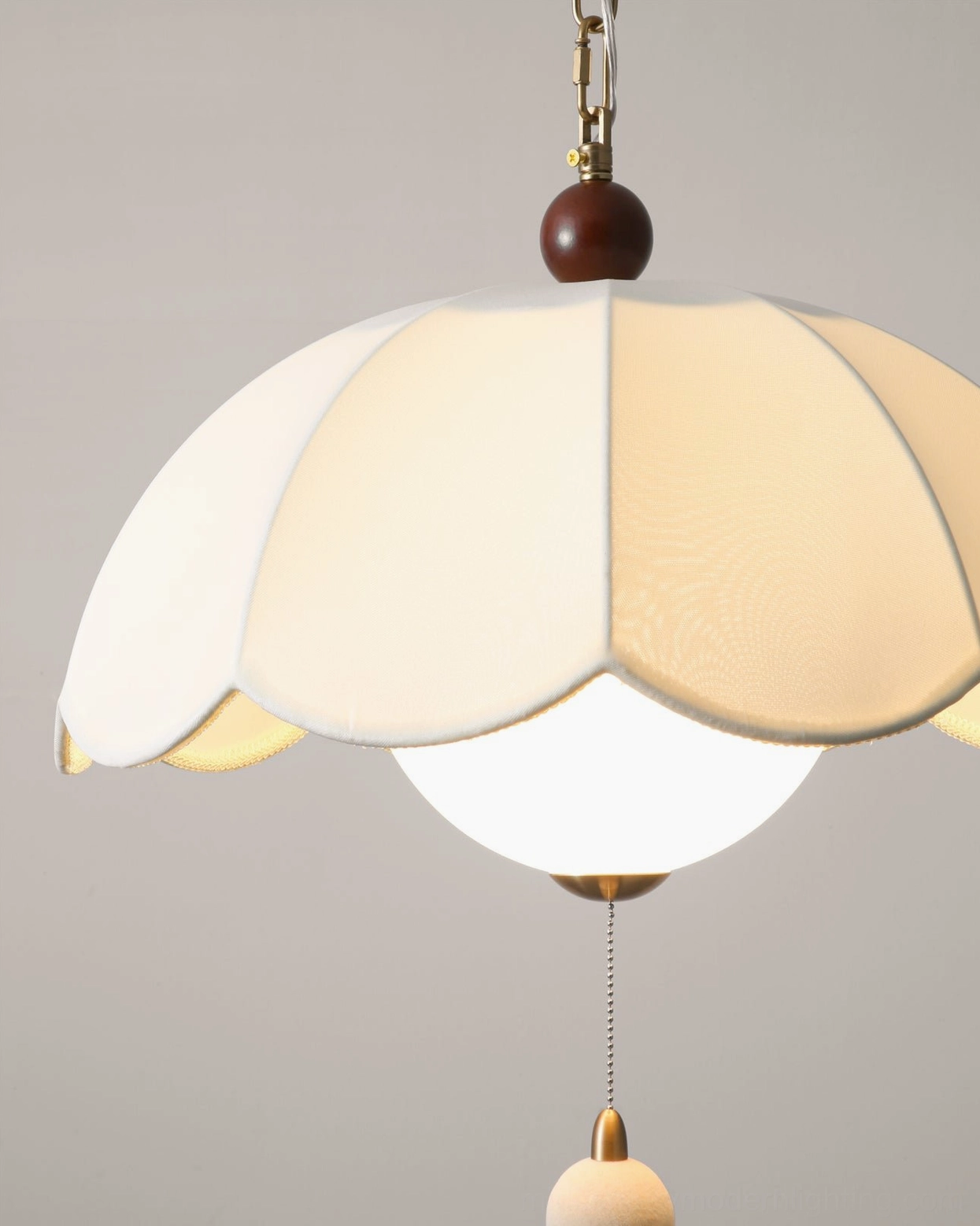 Oriente pendant light detail with off-white fabric shade and spherical fabric pull switch