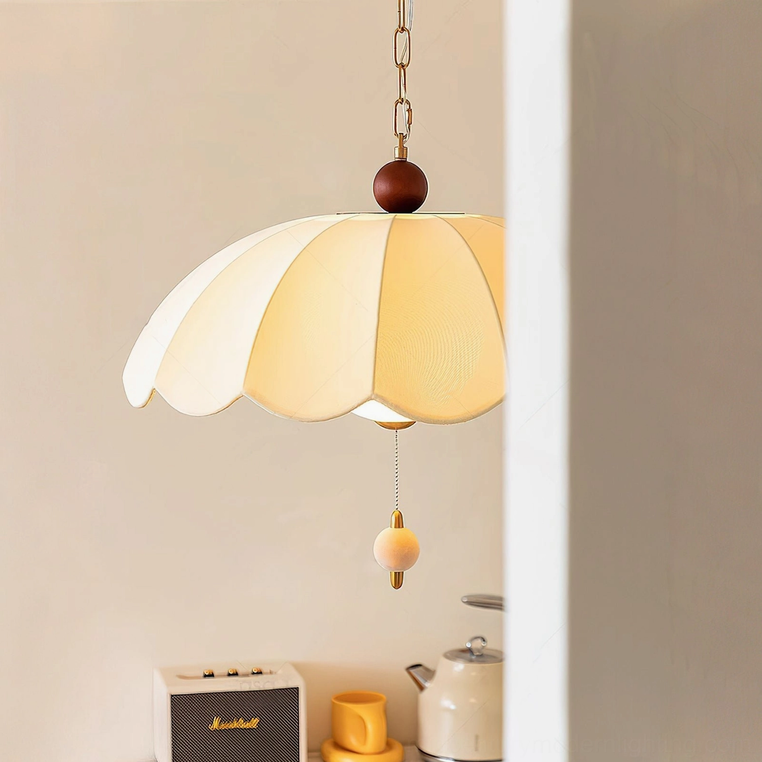 Oriente pendant ceiling light with layered scalloped shade and spherical pull switch, side view on shelf background