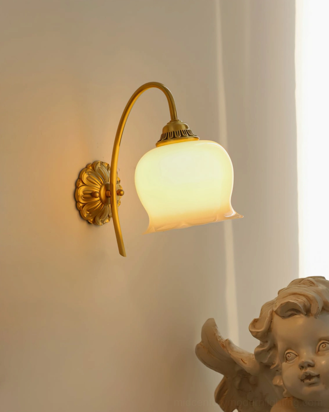 Lit brass wall lamp with curved arms and flower-shaped shade casting warm yellow light indoors