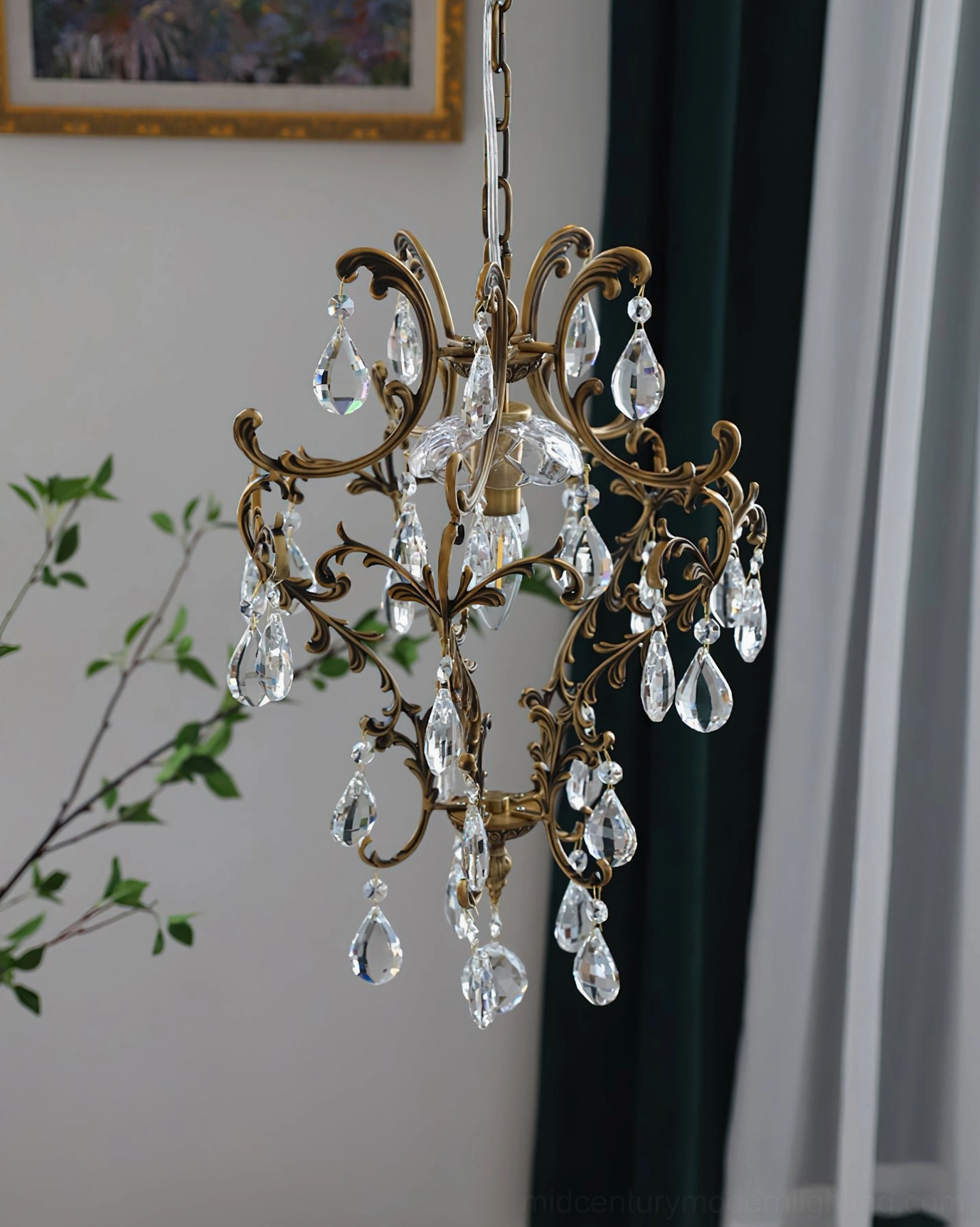 Ornate bronze birdcage pendant with clear crystal teardrop accents in romantic classic interior with dark green curtains