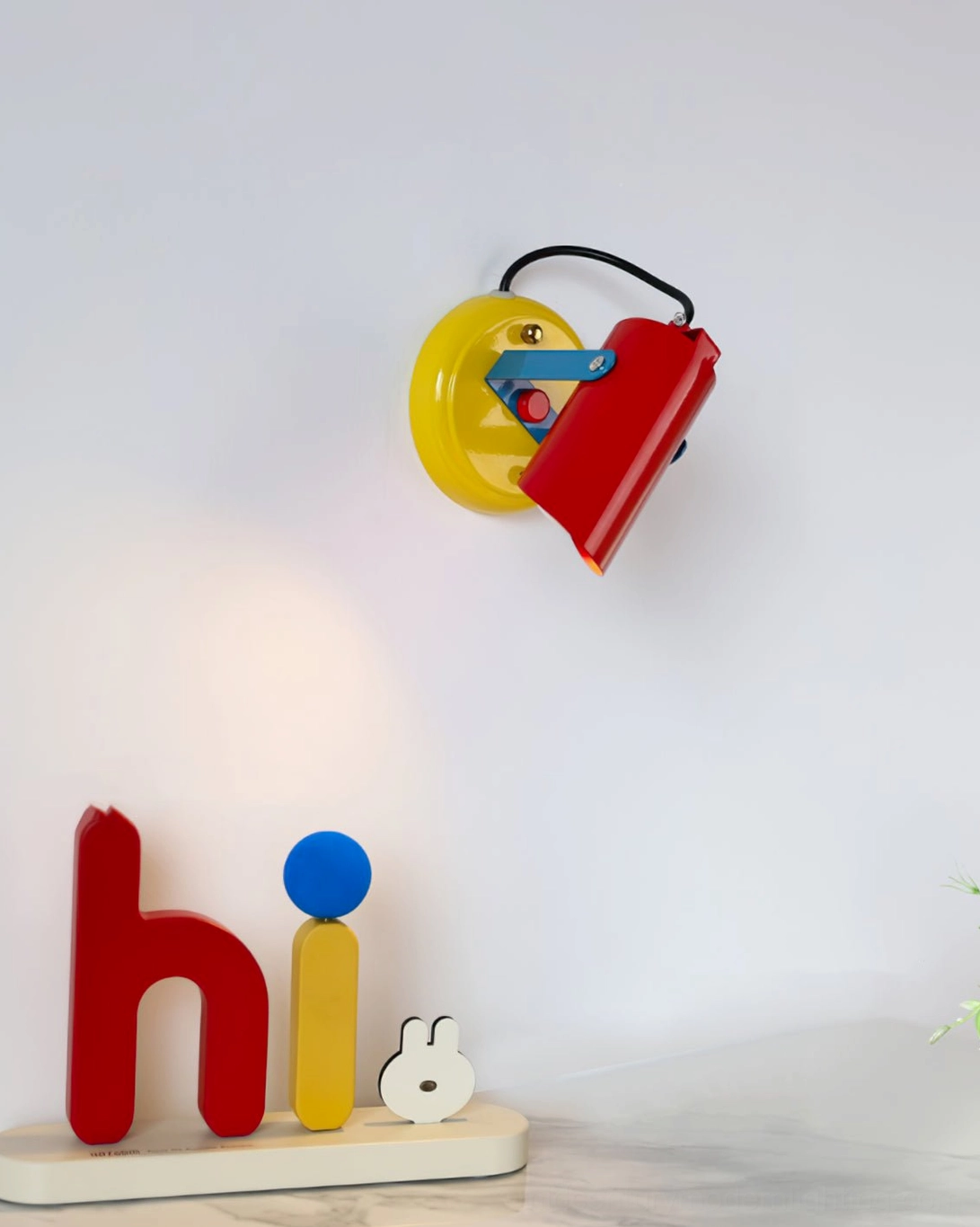 Orno small wall lamp distant view installed on home wall near tabletop with decorative letter ornaments