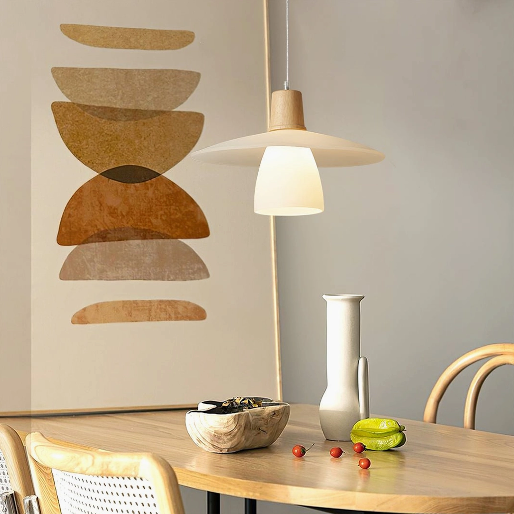 Matching pair of minimalist pendant lights above wooden dining table with boho style wall art