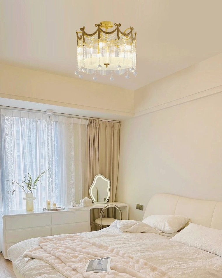 Crystal ceiling fixture in bedroom with vanity desk and light warm bedding minimalist decor