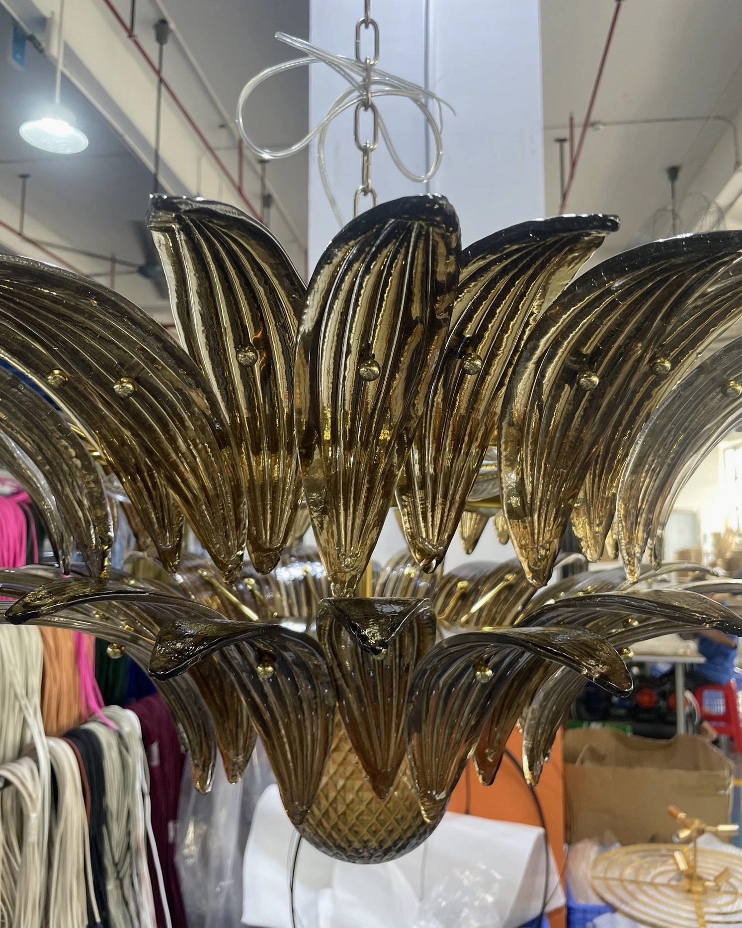 Close-up of Palazzo Ball Chandelier brass gold frame with amber glass showing finish detail and construction
