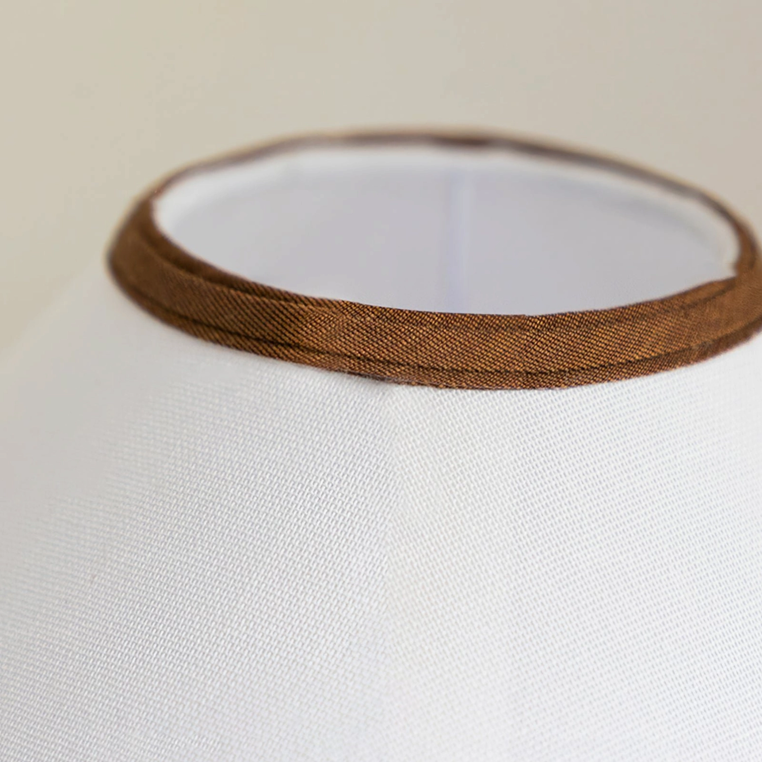 Close-up detail of Palisades lamp shade showing white woven fabric with brown double-layered edge trim