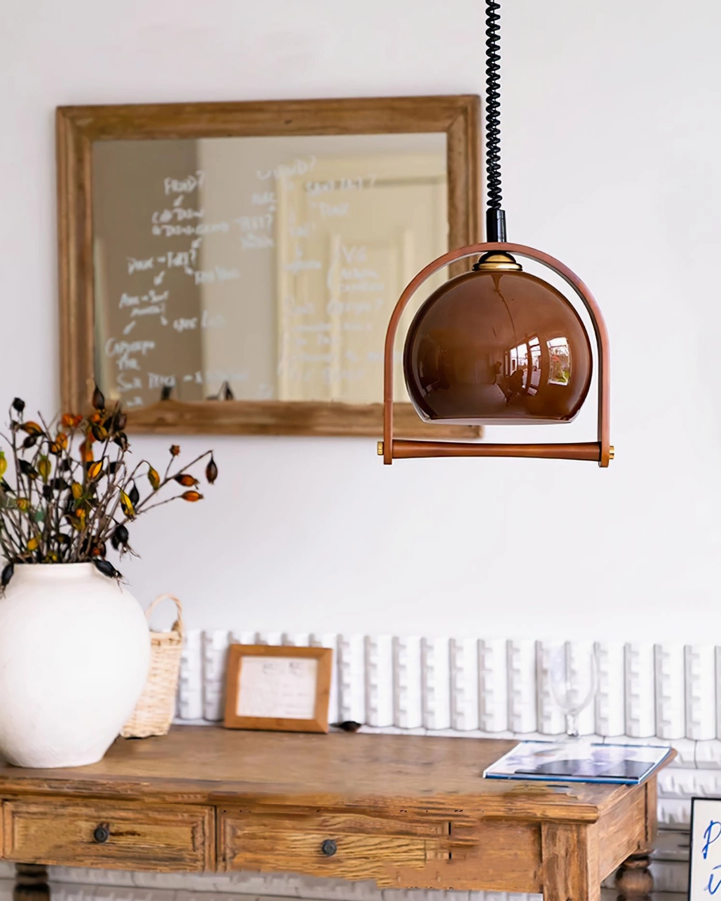Pallade walnut frame pendant lamp illuminated showing warm light diffusion through amber glass